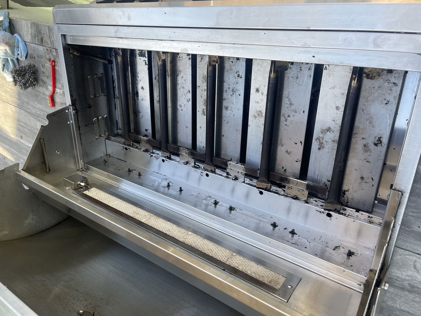 Commercial grill burners being deep cleaned